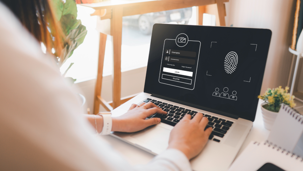 User logging into secure system with fingerprint authentication on laptop.